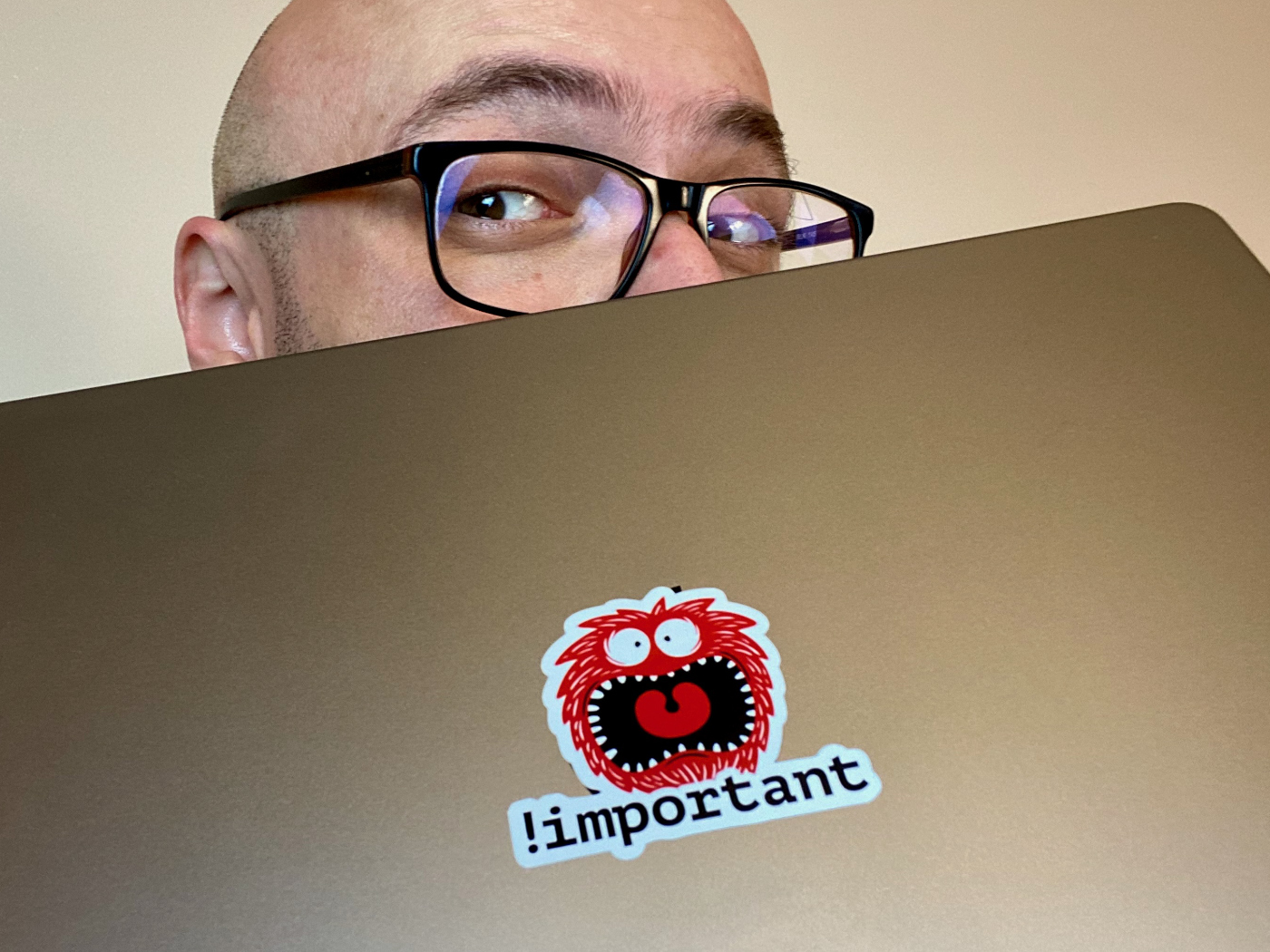 Zoran Jambor holding his laptop with the sticker !important in the middle.